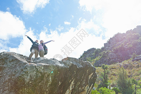 两个徒步旅行者在岩石上庆祝登顶图片