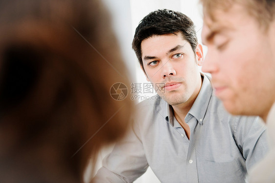 男同事看着正在说话的另一名男同事图片