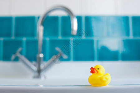 浴缸旁的黄色橡皮鸭背景图片
