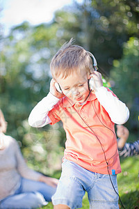 男孩在户外带耳机听音乐图片