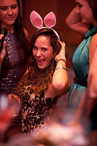 在派对上戴兔子耳朵的青年妇女图片