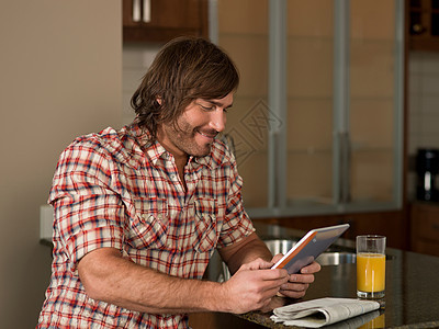 中年男子在桌子上使用平板电脑图片