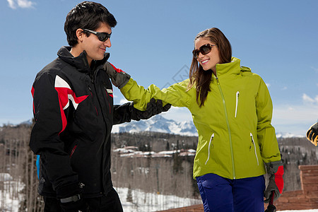 在滑雪斜坡上配备教练的年轻妇女图片
