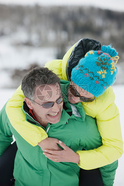 男子背着女人在雪地里面行走图片