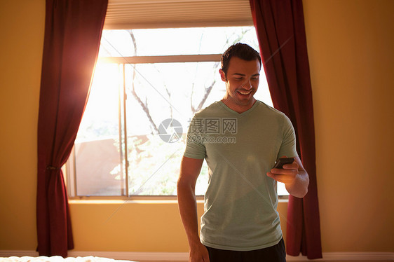 酒店内年轻男子拿着手机笑着图片