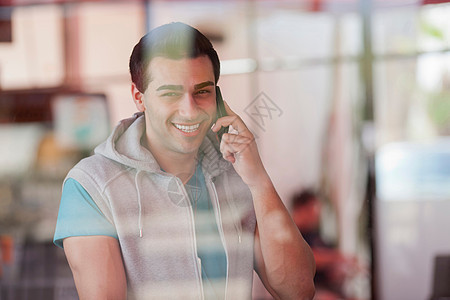 年轻人在餐厅窗口使用手机背景图片