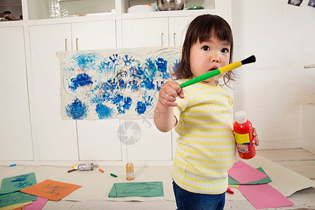 持有油漆瓶和刷子的女幼儿图片