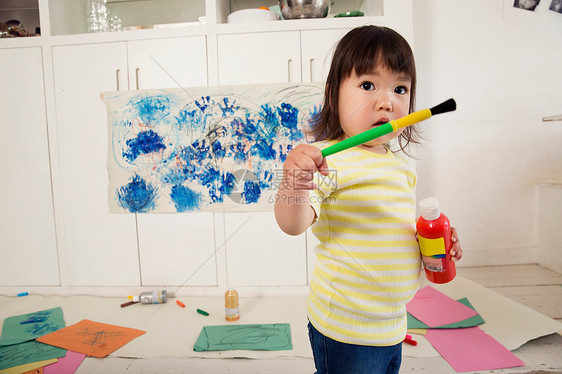 持有油漆瓶和刷子的女幼儿图片