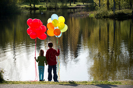 湖对面的兄妹带着一堆气球图片