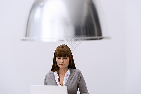 大型灯罩下面的膝上型电脑后面的妇女图片