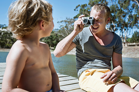 男人拍孩子坐在码头的照片图片