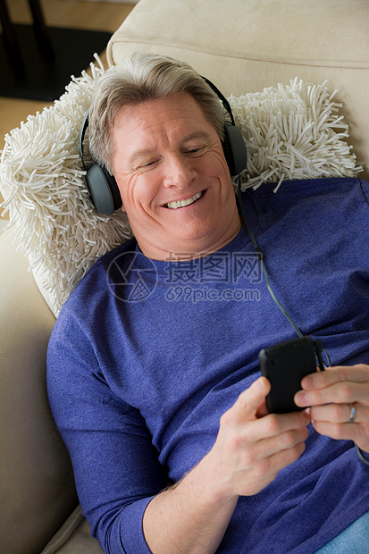 戴耳机笑着的成熟男子图片