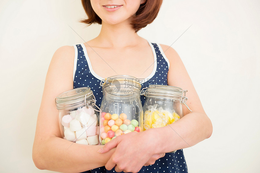 抱着三罐糖果的成年女性图片