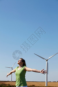 风力车前张开手臂的年轻女人图片
