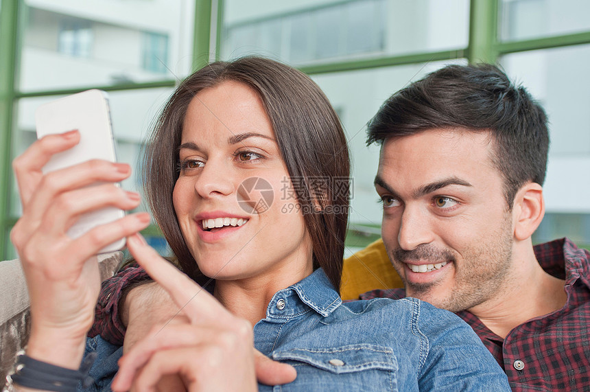 客厅里分享手机内容的夫妻两人图片