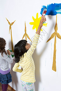 两个女孩在墙上画风力涡轮机图片