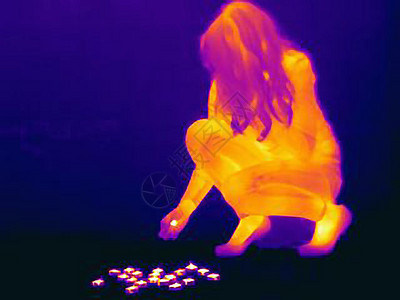 年轻女士把蜡烛放在地板上图片