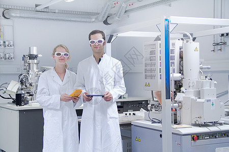 站在实验室里两名身着实验室外衣的科学家图片