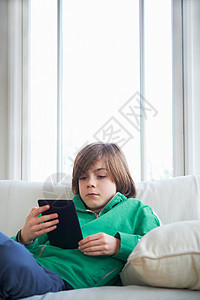 沙发上男孩使用数字平板电脑图片