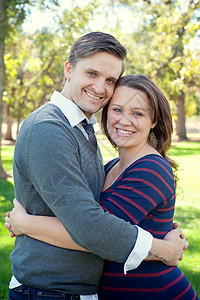 在公园里拥抱的年轻夫妇图片