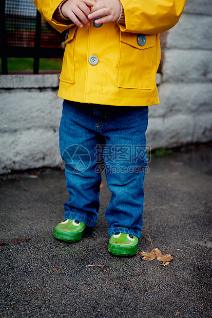 身穿黄色雨衣的小孩子特写图片