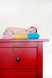 睡在红色抽屉顶上的新生儿图片
