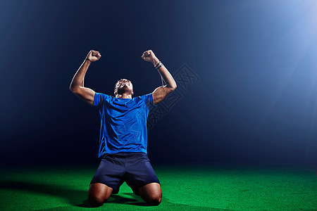 男足球运动员开心的跪下举起双臂图片