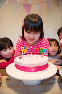 女孩在蛋糕上看生日蜡烛图片