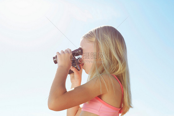 小女孩透过望远镜看远方图片