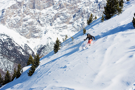 雪山上滑雪的女滑雪者图片