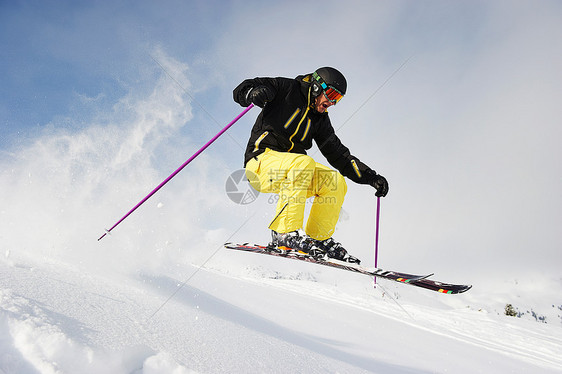 跳跃到空中的滑雪者图片
