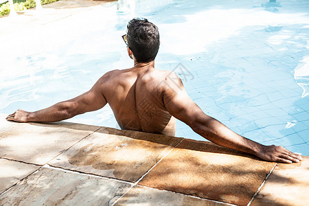 在游泳池里放松的男性图片