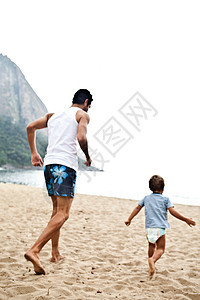 父亲和儿子在海滩上玩耍图片