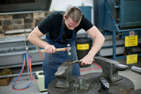 在创造工作室里用锤子做加工的人图片素材