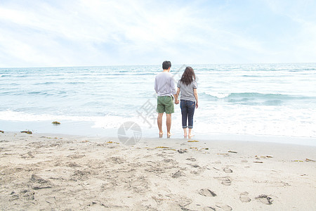握手看海的年轻夫妇图片