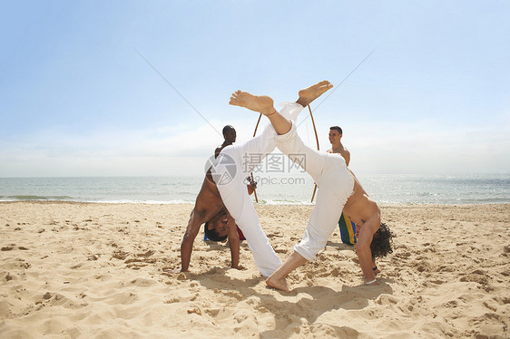 男人在海滩上做卡波伊拉图片