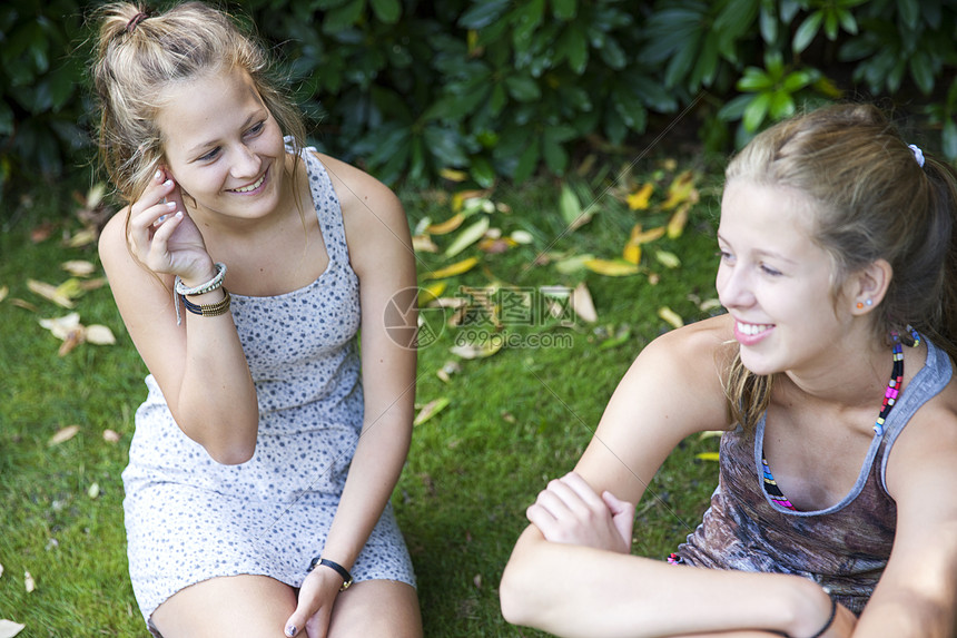 两个女孩坐在花园里图片