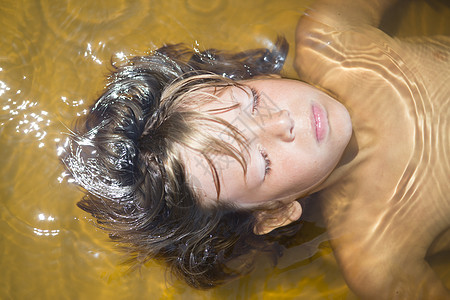 男孩漂浮在水中图片