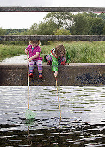 两名女孩坐在桥上钓鱼图片