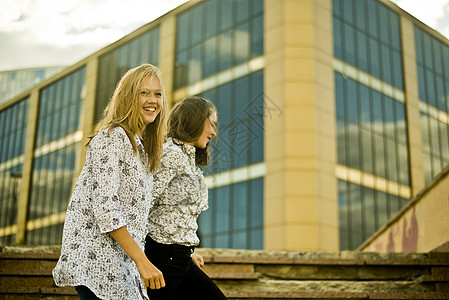 两名年轻妇女走在办公大楼前图片