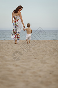 走在沙滩上的母亲和儿子图片