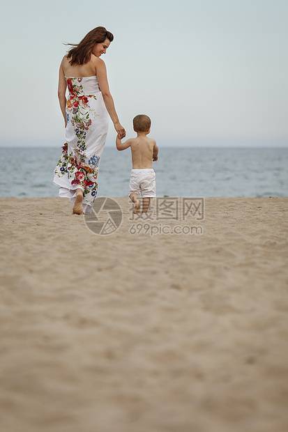 走在沙滩上的母亲和儿子图片