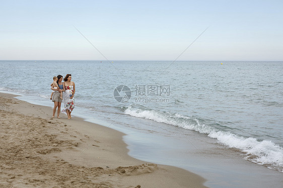 妇女抱着婴儿在岸边行走图片