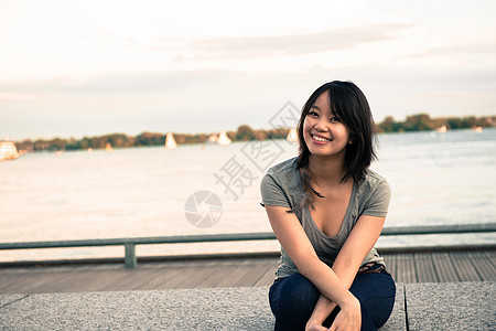 坐在水边的年轻妇女图片