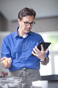 男人拿着鸡蛋和平板电脑图片