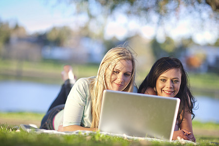 在草坪上看书学习的青年女学生图片