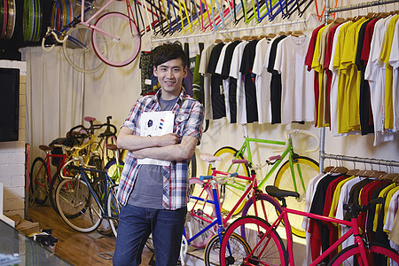年轻男子在自行车店微笑图片