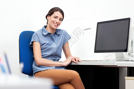 坐在办公室桌前的年轻妇女图片