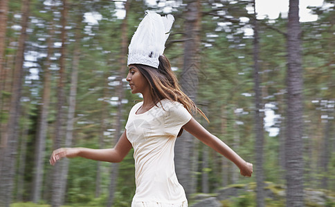 身戴白帽子的少女在森林里奔跑图片