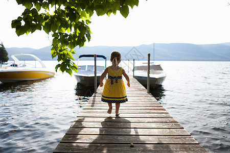 站在湖边码头的小女孩图片